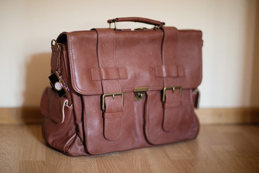 a brown leather briefcase sitting on top of a wooden floor